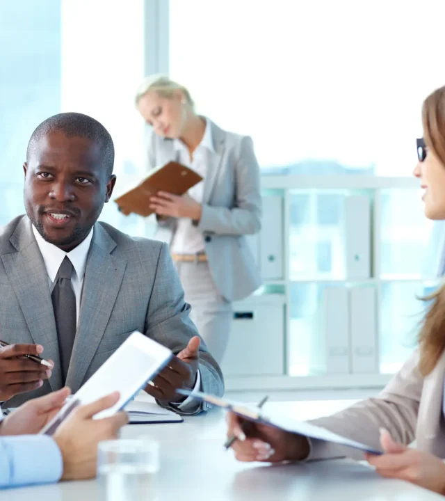 Portrait of confident boss looking at employee during interaction at meeting